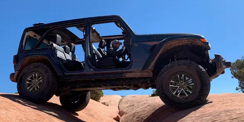 A Jeep Wrangler crawling desert rocks